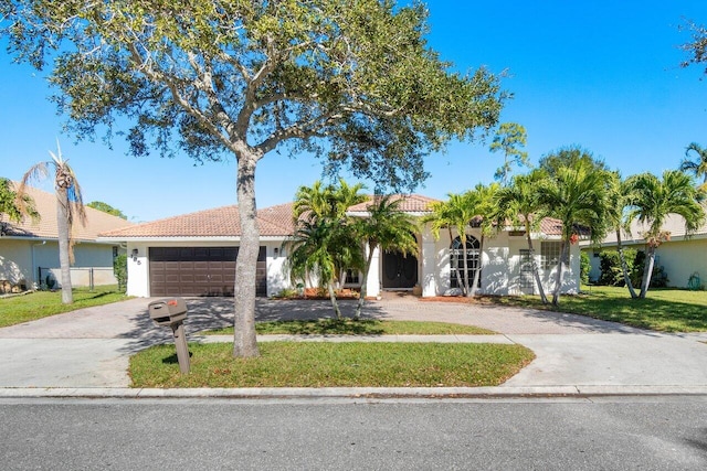 mediterranean / spanish home featuring a garage and a front lawn