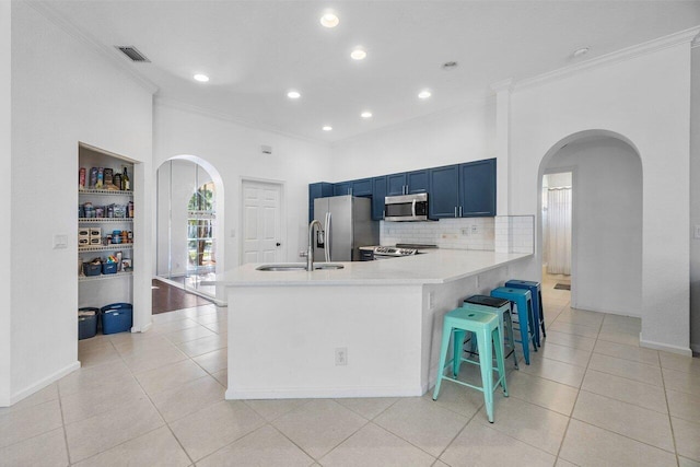 kitchen with appliances with stainless steel finishes, light tile patterned floors, a breakfast bar area, and sink