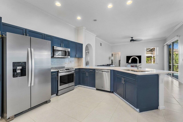 kitchen with kitchen peninsula, appliances with stainless steel finishes, blue cabinets, and sink