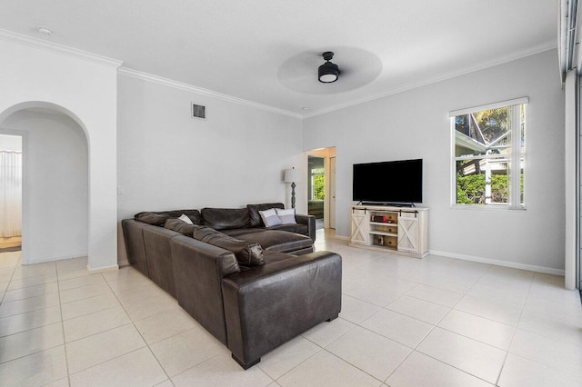 tiled living room with ceiling fan and crown molding