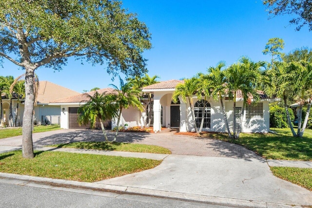 view of front of house featuring a front lawn and a garage