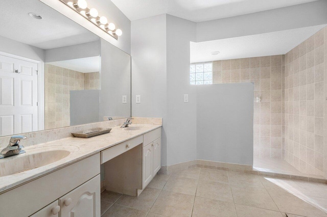 bathroom with tile patterned flooring, vanity, a shower, and tile walls