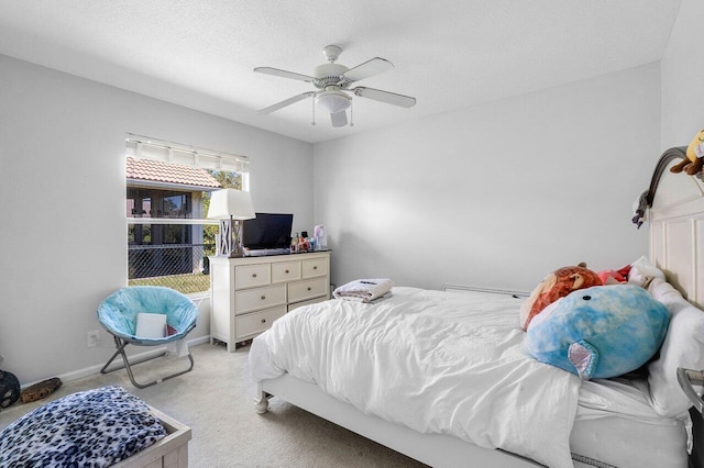 bedroom featuring a textured ceiling, ceiling fan, and light carpet