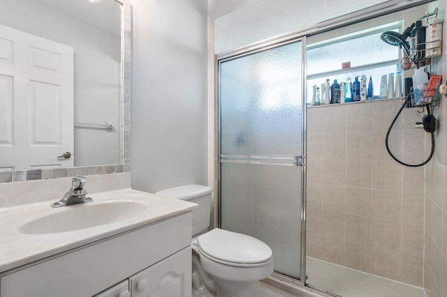 bathroom featuring toilet, vanity, and walk in shower