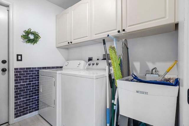 laundry room featuring washing machine and dryer, sink, light tile patterned flooring, and cabinets