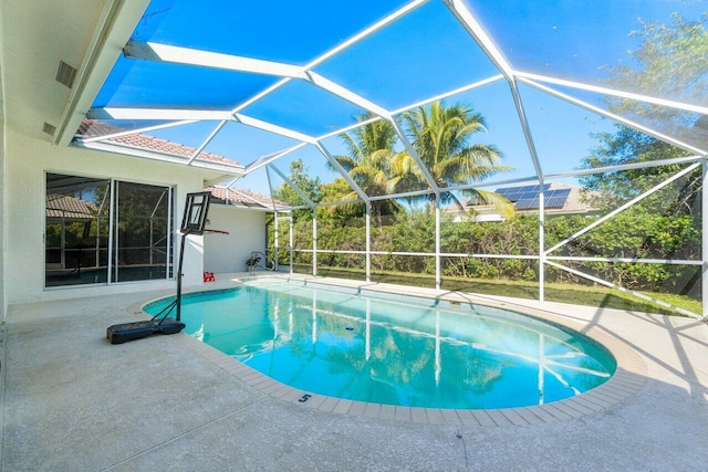 view of pool with a patio and glass enclosure