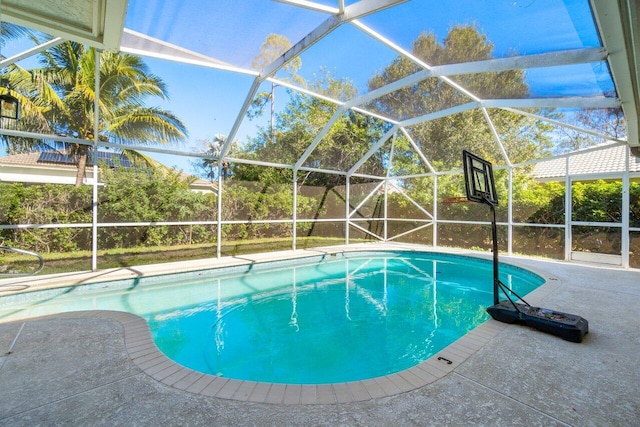 view of pool with a patio and glass enclosure