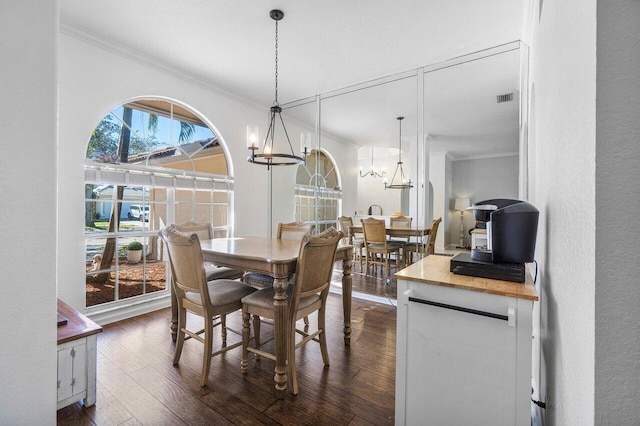 dining space featuring a chandelier, dark hardwood / wood-style floors, and ornamental molding