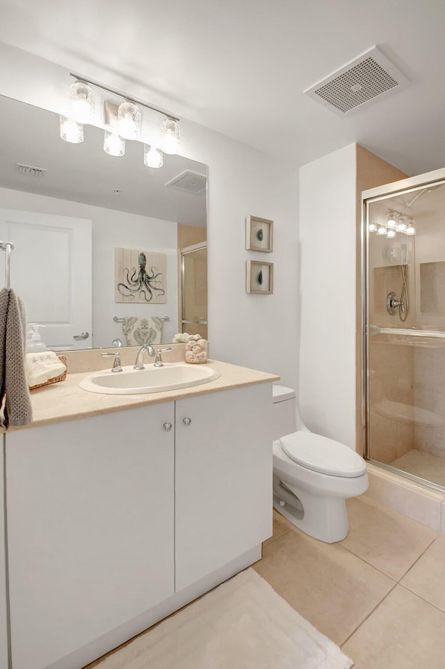 bathroom with toilet, vanity, tile patterned flooring, and a shower with door