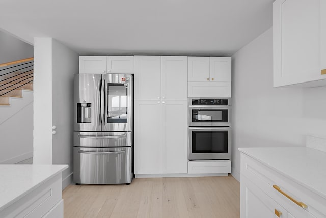 kitchen with white cabinetry, light hardwood / wood-style flooring, and appliances with stainless steel finishes