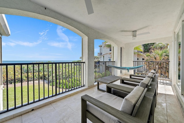 balcony featuring a water view and ceiling fan