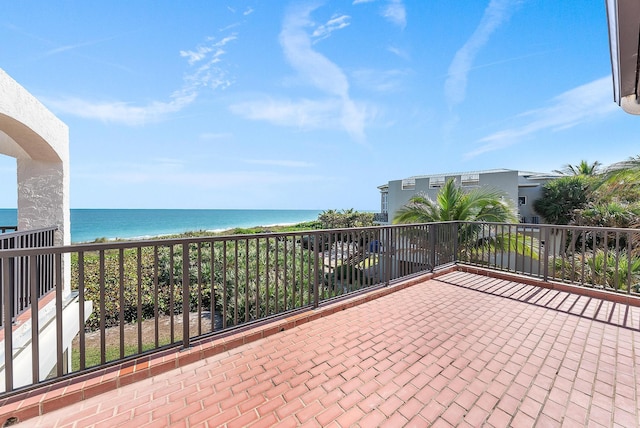 view of patio with a water view and a balcony