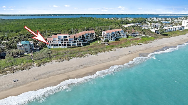 birds eye view of property featuring a water view and a beach view