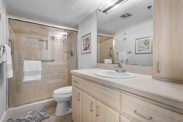 bathroom with tile patterned flooring, vanity, an enclosed shower, and toilet