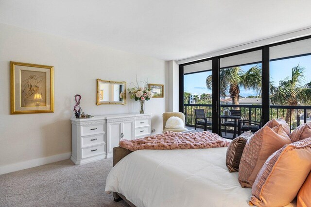 carpeted bedroom featuring access to exterior and a wall of windows