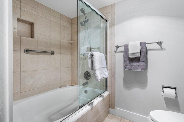 bathroom with combined bath / shower with glass door and toilet