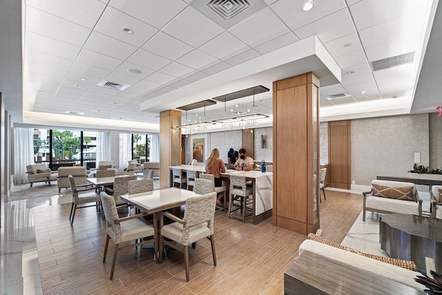 dining space featuring a raised ceiling and a drop ceiling