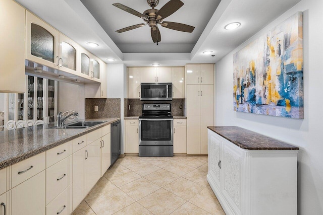 kitchen featuring appliances with stainless steel finishes, tasteful backsplash, ceiling fan, sink, and cream cabinetry