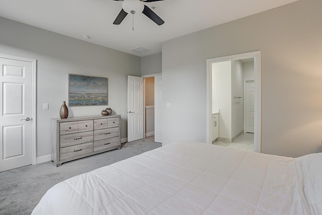 bedroom featuring connected bathroom, light colored carpet, and ceiling fan