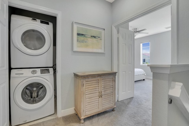 washroom featuring ceiling fan, light colored carpet, and stacked washer / drying machine