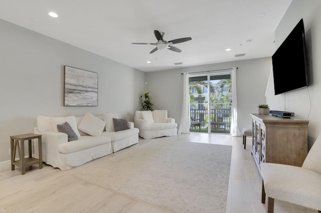 living room featuring light hardwood / wood-style flooring and ceiling fan