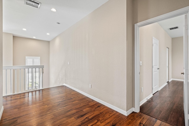 unfurnished room featuring dark wood-style flooring, recessed lighting, visible vents, and baseboards