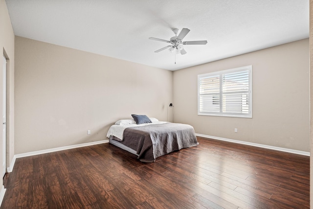 bedroom with a ceiling fan, baseboards, and wood finished floors