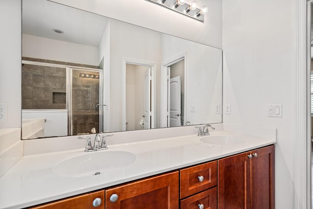 full bath featuring a stall shower, a sink, toilet, and double vanity