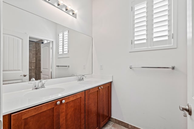 full bath with double vanity, a sink, and baseboards