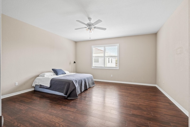 bedroom featuring ceiling fan, baseboards, and wood finished floors