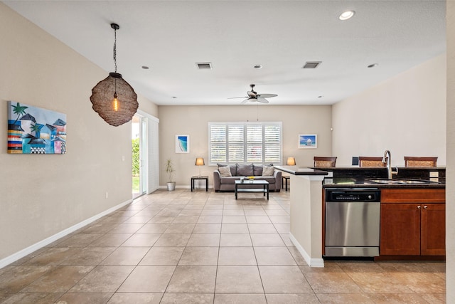 kitchen featuring dark countertops, visible vents, open floor plan, a sink, and dishwasher