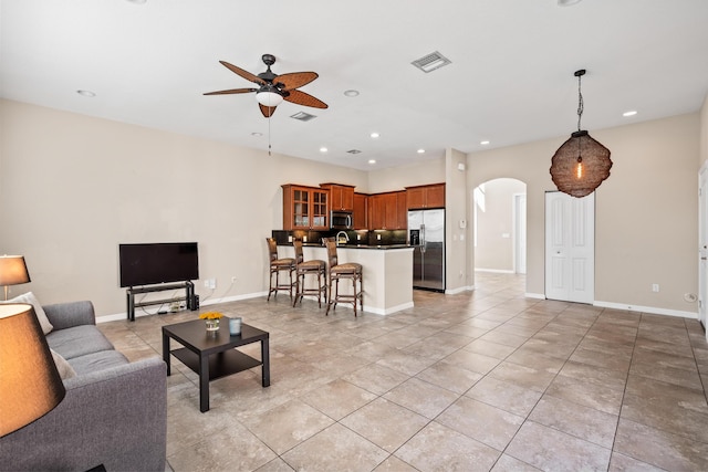 living room featuring arched walkways, visible vents, a ceiling fan, and recessed lighting