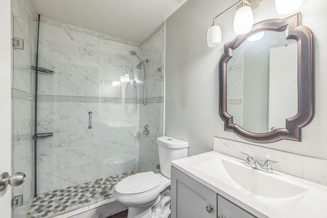 bathroom featuring vanity, toilet, and a shower with shower door