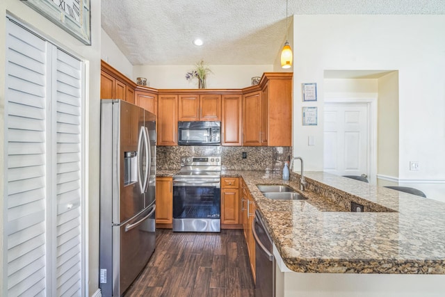 kitchen with backsplash, sink, dark hardwood / wood-style floors, kitchen peninsula, and stainless steel appliances