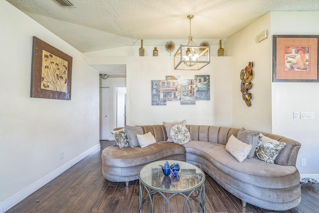 living room with a textured ceiling, dark hardwood / wood-style floors, vaulted ceiling, and a notable chandelier