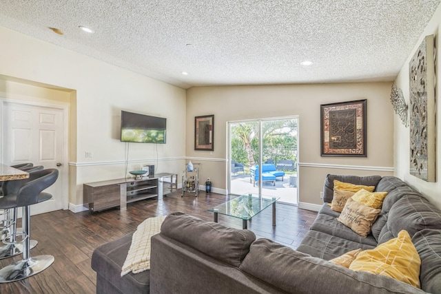 living room with lofted ceiling, dark hardwood / wood-style flooring, and a textured ceiling