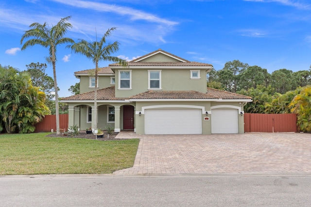 mediterranean / spanish-style home featuring a garage and a front lawn