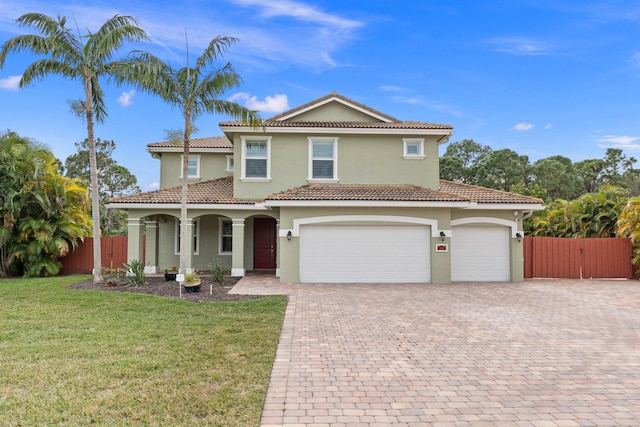 mediterranean / spanish house featuring a front lawn and a garage