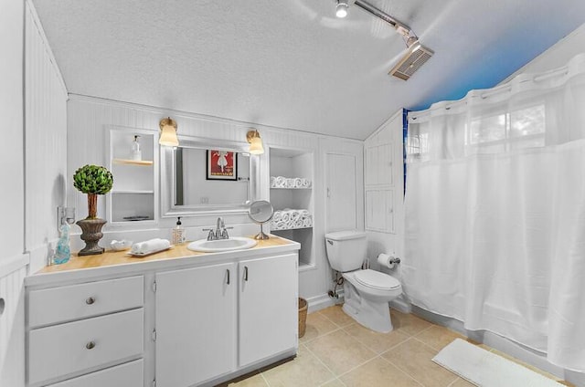 bathroom featuring vanity, a textured ceiling, vaulted ceiling, tile patterned floors, and toilet