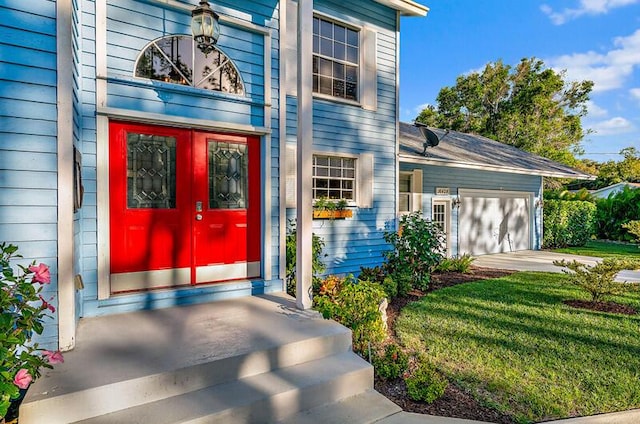 property entrance featuring a garage and a yard