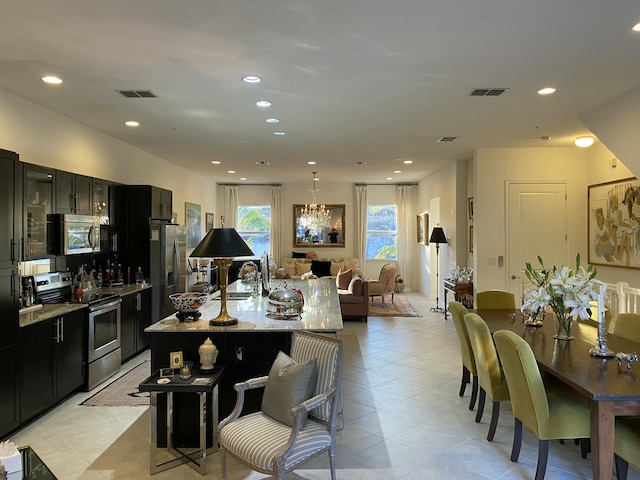 interior space with light stone countertops, a breakfast bar, appliances with stainless steel finishes, and an island with sink