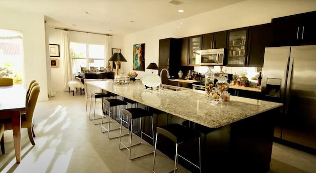 kitchen featuring sink, appliances with stainless steel finishes, a kitchen breakfast bar, and a spacious island