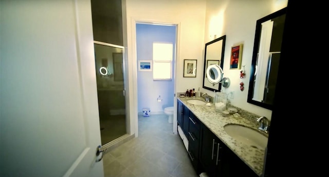 bathroom with toilet, a shower with shower door, and vanity