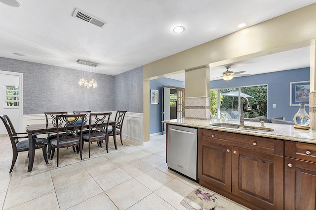 kitchen featuring light stone counters, a wainscoted wall, visible vents, a sink, and dishwasher