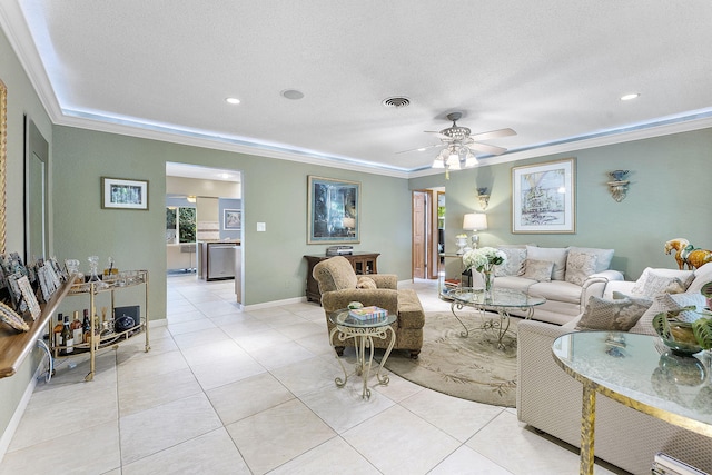 living area featuring light tile patterned floors, ceiling fan, visible vents, and crown molding