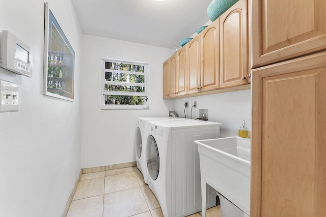 clothes washing area with cabinets, independent washer and dryer, and light tile patterned floors