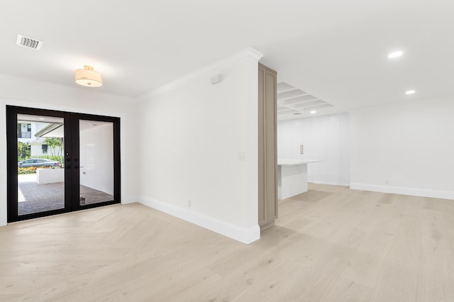 spare room featuring crown molding, french doors, and light wood-type flooring