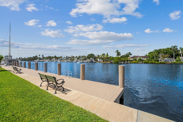 view of dock featuring a lawn and a water view