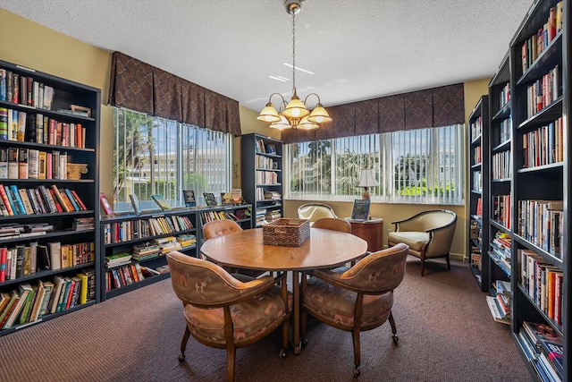 carpeted dining space featuring a textured ceiling, a wealth of natural light, and a chandelier