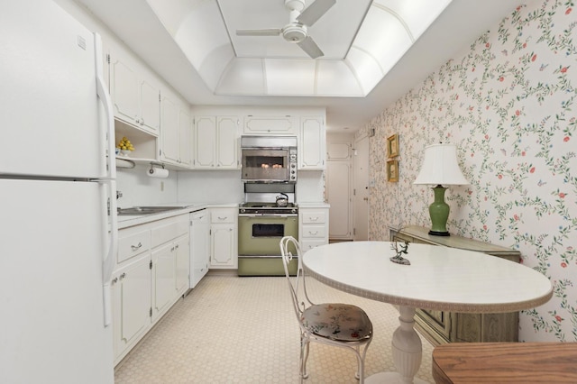 kitchen featuring a breakfast bar area, ceiling fan, white cabinets, and stainless steel appliances